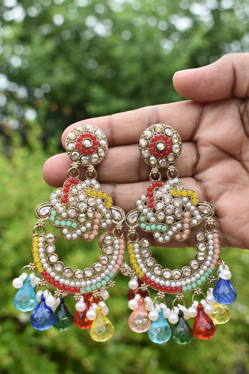Colorful beaded keychain held in a hand with a blurred green background
